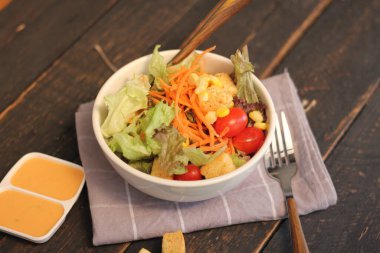 Sezar salatası ve Sezar sosu. Siyah ahşap bir masada.