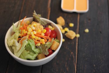 Sezar salatası ve Sezar sosu. Siyah ahşap bir masada.