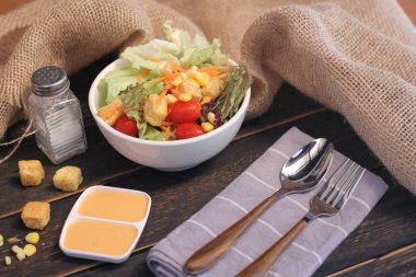 Sezar salatası ve Sezar sosu. Siyah ahşap bir masada.