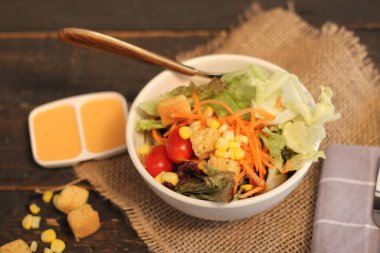 Sezar salatası ve Sezar sosu. Siyah ahşap bir masada.