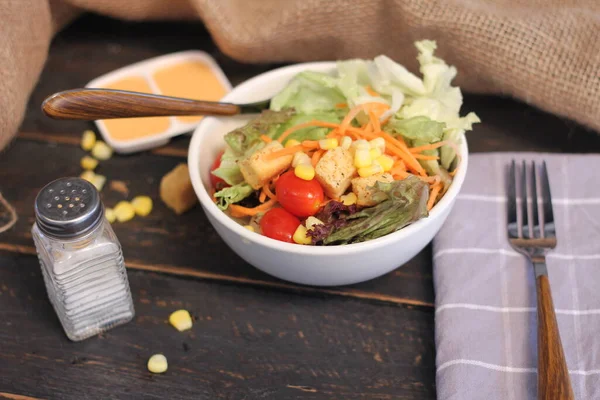 Sezar salatası ve Sezar sosu. Siyah ahşap bir masada.