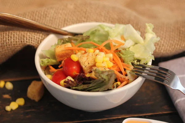 Sezar salatası ve Sezar sosu. Siyah ahşap bir masada.