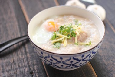 Siyah ahşap bir masada servis edilen Tayland usulü bir fincanda şaka ya da congee. Asya kahvaltısı..