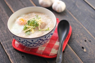 Siyah ahşap bir masada servis edilen Tayland usulü bir fincanda şaka ya da congee. Asya kahvaltısı..