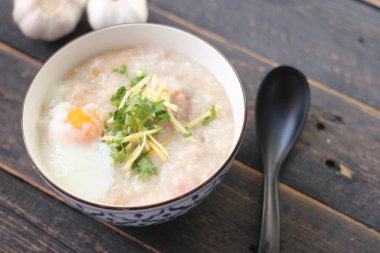 Siyah ahşap bir masada servis edilen Tayland usulü bir fincanda şaka ya da congee. Asya kahvaltısı..