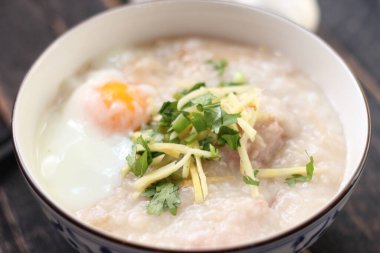 Siyah ahşap bir masada servis edilen Tayland usulü bir fincanda şaka ya da congee. Asya kahvaltısı..