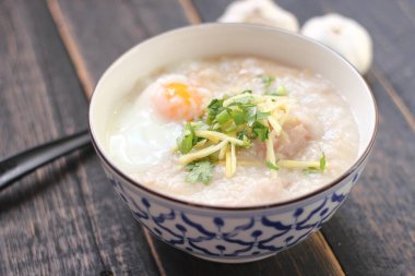 Siyah ahşap bir masada servis edilen Tayland usulü bir fincanda şaka ya da congee. Asya kahvaltısı..