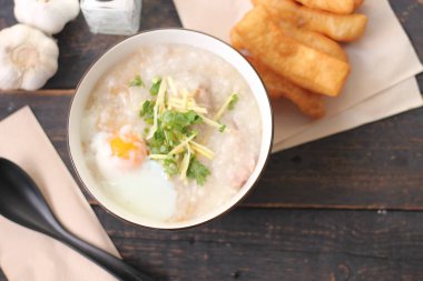 Siyah ahşap bir masada servis edilen Tayland usulü bir fincanda şaka ya da congee. Asya kahvaltısı. en üstteki görünümde