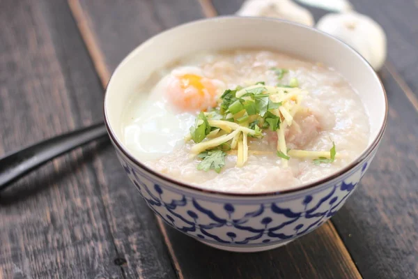 Siyah ahşap bir masada servis edilen Tayland usulü bir fincanda şaka ya da congee. Asya kahvaltısı..
