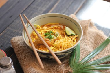 Khao Soi Recipe, Khao Soi, Khao Soi Kai, Thai Noodles Khao Soi, Ahşap masada servis edilen baharatlı Tavuk Köri.