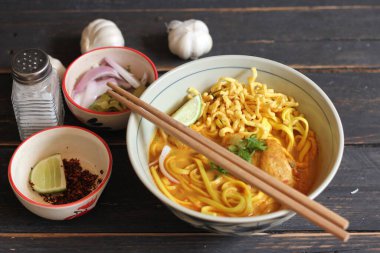 Khao Soi Recipe, Khao Soi, Khao Soi Kai, Thai Noodles Khao Soi, Ahşap masada servis edilen baharatlı Tavuk Köri.