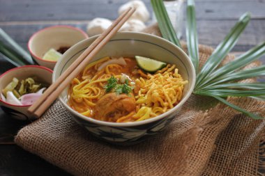 Khao Soi Recipe, Khao Soi, Khao Soi Kai, Thai Noodles Khao Soi, Ahşap masada servis edilen baharatlı Tavuk Köri.