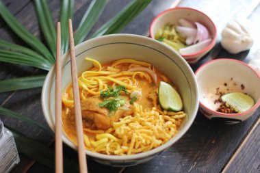 Khao Soi Recipe, Khao Soi, Khao Soi Kai, Thai Noodles Khao Soi, Ahşap masada servis edilen baharatlı Tavuk Köri.