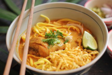 Khao Soi Recipe, Khao Soi, Khao Soi Kai, Thai Noodles Khao Soi, Ahşap masada servis edilen baharatlı Tavuk Köri.