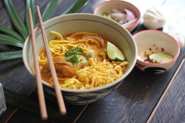 Khao Soi Recipe, Khao Soi, Khao Soi Kai, Thai Noodles Khao Soi, Ahşap masada servis edilen baharatlı Tavuk Köri.
