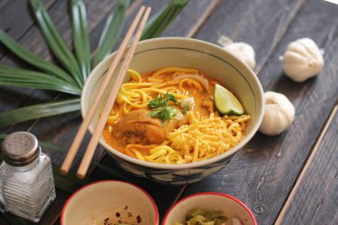 Khao Soi Recipe, Khao Soi, Khao Soi Kai, Thai Noodles Khao Soi, Ahşap masada servis edilen baharatlı Tavuk Köri.