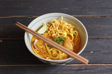 Khao Soi Recipe, Khao Soi, Khao Soi Kai, Thai Noodles Khao Soi, Ahşap masada servis edilen baharatlı Tavuk Köri.