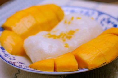 Hindistan cevizi sütü ve soya fasulyesiyle kaplanmış mangolu pirinç Tayland 'da ahşap bir masada geleneksel Çin usulü bir yemeğe konur..