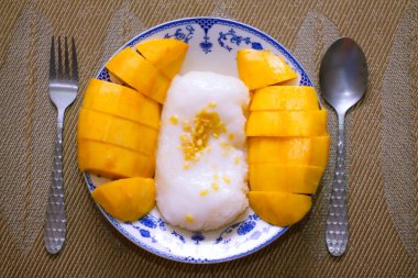 Hindistan cevizi sütü ve soya fasulyesiyle kaplanmış mangolu pirinç Tayland 'da ahşap bir masada geleneksel Çin usulü bir yemeğe konur..