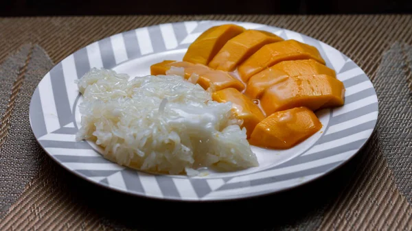 Mango sticky rice topped with coconut milk and soybeans