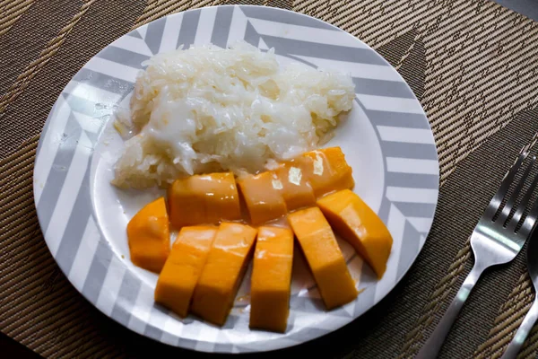Mango sticky rice topped with coconut milk and soybeans