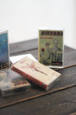 Bangkok, Tayland - 22 Ocak 2022: 90: Nirvana Albums Incesticide, Nevermind, Bleach, The Muddy Banks of The Wishkah 'ın siyah ahşap zemin üzerindeki kasetleri.