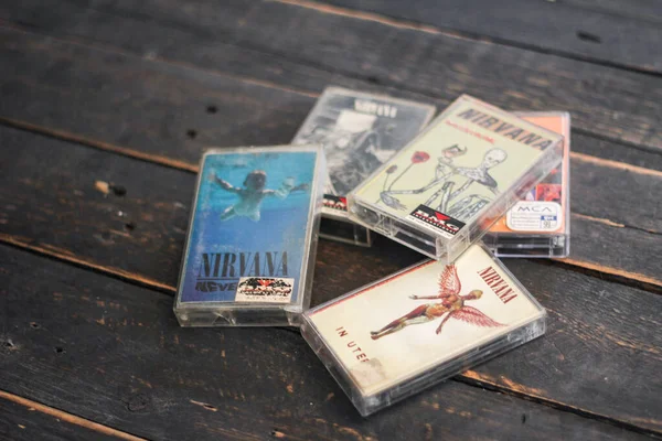 Bangkok, Tayland - 22 Ocak 2022: 90: Nirvana Albums Incesticide, Nevermind, Bleach, The Muddy Banks of The Wishkah 'ın siyah ahşap zemin üzerindeki kasetleri.