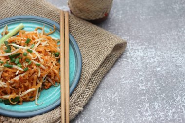 Tayland yemeği Pad Thai Thai kızarmış eriştesi (ulusal yemek) mavi tabakta servis edilir..