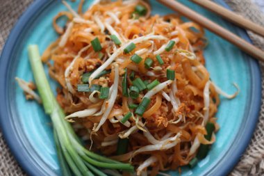 Tayland yemeği Pad Thai Thai kızarmış eriştesi (ulusal yemek) mavi tabakta servis edilir..