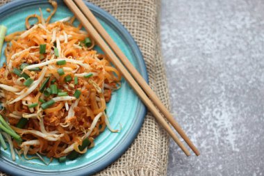 Tayland yemeği Pad Thai Thai kızarmış eriştesi (ulusal yemek) mavi tabakta servis edilir..