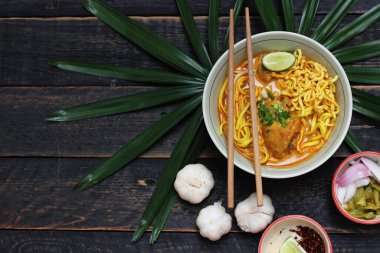 Khao Soi Recipe, Khao Soi, Khao Soi Kai, Thai Noodles Khao Soi, Ahşap masada servis edilen baharatlı Tavuk Köri.