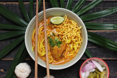 Khao Soi Recipe, Khao Soi, Khao Soi Kai, Thai Noodles Khao Soi, Ahşap masada servis edilen baharatlı Tavuk Köri.