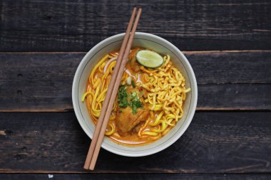Khao Soi Recipe, Khao Soi, Khao Soi Kai, Thai Noodles Khao Soi, Ahşap masada servis edilen baharatlı Tavuk Köri.