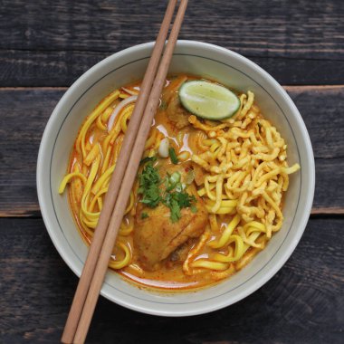 Khao Soi Recipe, Khao Soi, Khao Soi Kai, Thai Noodles Khao Soi, Ahşap masada servis edilen baharatlı Tavuk Köri.