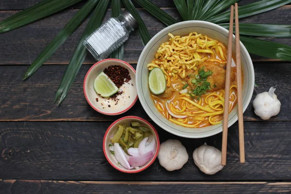 カオソイレシピ カオソイ カオソイカイ タイ麺カオソイ 木製のテーブルで提供調味料とチキンカレー — ストック写真