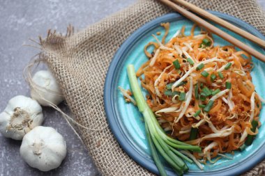 Tayland yemeği Pad Thai Thai kızarmış eriştesi (ulusal yemek) mavi tabakta servis edilir..