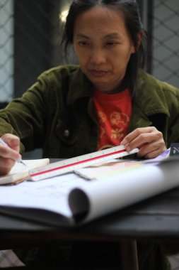 Asyalı kadın mühendisler inşaat alanındaki çizimler üzerinde çalışıyorlar..