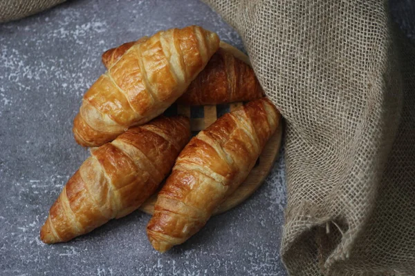 Croissant Pão Empilhado Mesa Com Placas Madeira Pano Saco — Fotografia de Stock