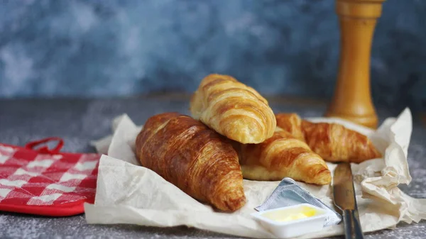 Pile Delicious Fresh Croissants Served Butter Gray Table Blue Background — Stock Photo, Image