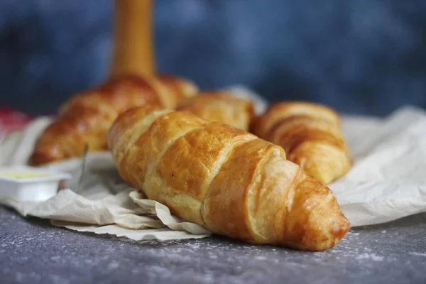 Pile Delicious Fresh Croissants Served Butter Gray Table Blue Background — Stock Photo, Image