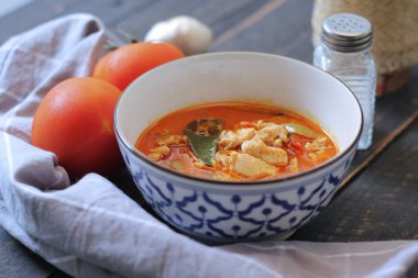 Tayland usulü bir tabakta siyah ahşap bir masada servis edilen tavuk pananjiri..