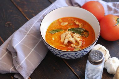 Tayland usulü bir tabakta siyah ahşap bir masada servis edilen tavuk pananjiri..