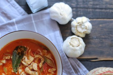 Tayland usulü bir tabakta siyah ahşap bir masada servis edilen tavuk pananjiri..