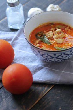 Tayland usulü bir tabakta siyah ahşap bir masada servis edilen tavuk pananjiri..