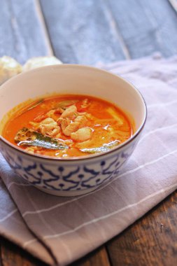 Tayland usulü bir tabakta siyah ahşap bir masada servis edilen tavuk pananjiri..