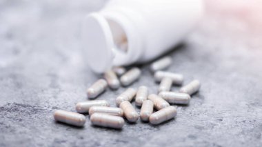 Gri kapsül ve ilaç şişeleri gri masaya yerleştirildi..