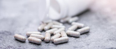 Gri kapsül ve ilaç şişeleri gri masaya yerleştirildi..