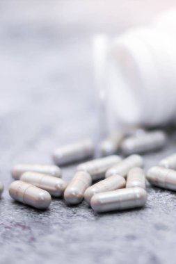 Gri kapsül ve ilaç şişeleri gri masaya yerleştirildi..