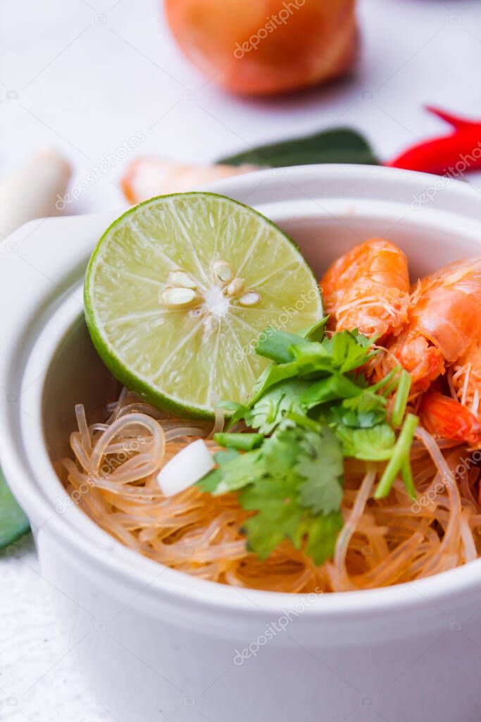 Shrimp potted with vermicelli is served in a white ceramic bowl 