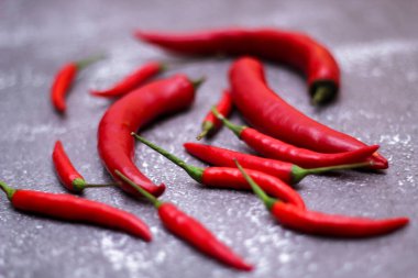 Kırmızı biber ve yeşil biber, gri masaya yayılmış sarımsak mutfakta pişirmeye hazır..